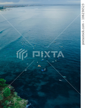 Drone view with a lot of surfers on line up in ocean at Bali in Nusa dua. Drone view with a lot of surfers on line up in ocean at Bali in Nusa dua. 106236523