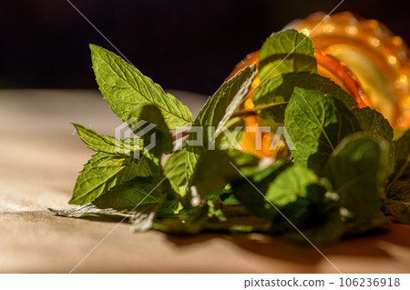 Green fresh mint leaves on wood sill in sunlight. Fresh herbs for health and food. Green fresh mint leaves on wood sill in sunlight. Fresh herbs for health and food. 106236918