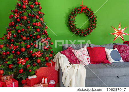 Christmas living room interior with sofa, Christmas tree and wreath on green background 106237047
