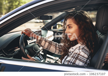 Portrait of a beautiful smiling woman in a car looking out of the window Portrait of a beautiful smiling woman in a car looking out of the window 106237107