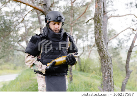 A man in a special suit works with a detector and found an explosive device 106237597