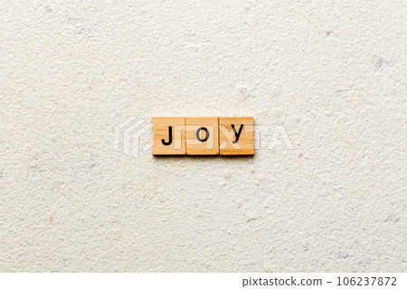 Joy word written on wood block. Joy text on cement table for your desing, concept 106237872