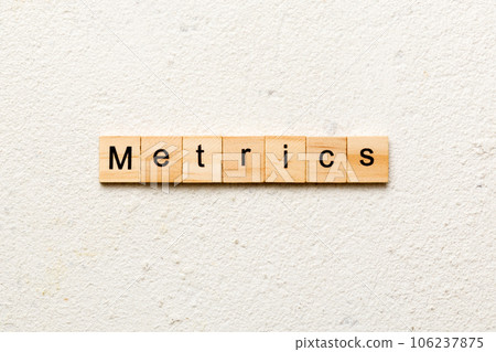 METRICS word written on wood block. METRICS text on cement table for your desing, concept METRICS word written on wood block. METRICS text on cement table for your desing, concept 106237875