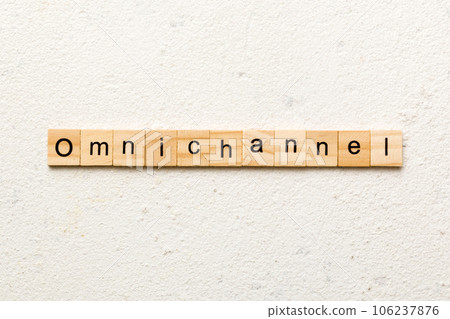 OMNICHANNEL word written on wood block. OMNICHANNEL text on cement table for your desing, concept 106237876