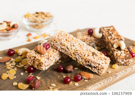 Various granola bars on table background. Cereal granola bars. Superfood breakfast bars with oats, nuts and berries, close up. Superfood concept 106237909