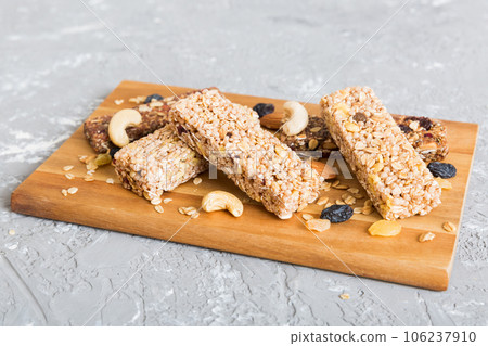 Various granola bars on table background. Cereal granola bars. Superfood breakfast bars with oats, nuts and berries, close up. Superfood concept Various granola bars on table background. Cereal granola bars. Superfood breakfast bars with oats, nuts and berries, close up. Superfood concept 106237910
