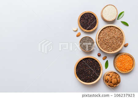 Various superfoods in smal bowl on colored background. Superfood as rice, chia, quinoa, lentils, nuts, sesame seeds, almonds. top view copy space Various superfoods in smal bowl on colored background. Superfood as rice, chia, quinoa, lentils, nuts, sesame seeds, almonds. top view copy space 106237923