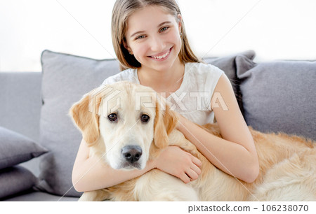 Smiling teenage girl with adorable dog in light room Smiling teenage girl with adorable dog in light room 106238070