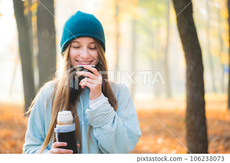 Sweet girl drinking tea in autumn nature 106238073