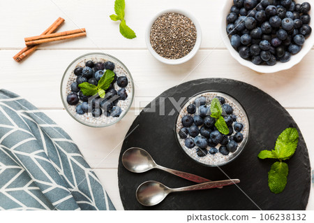 Healthy breakfast or morning with chia seeds vanilla pudding and blueberry berries on table background, vegetarian food, diet and health concept. Chia pudding with coconut milk and blueberry 106238132