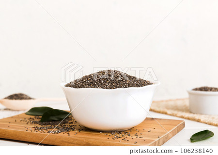 Chia seeds in bowl and spoon on colored background. Healthy Salvia hispanica in small bowl. Healthy superfood Chia seeds in bowl and spoon on colored background. Healthy Salvia hispanica in small bowl. Healthy superfood 106238140
