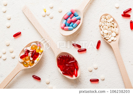 Vitamin capsules in a spoon on a colored background. Pills served as a healthy meal. Red soft gel vitamin supplement capsules on spoon Vitamin capsules in a spoon on a colored background. Pills served as a healthy meal. Red soft gel vitamin supplement capsules on spoon 106238203