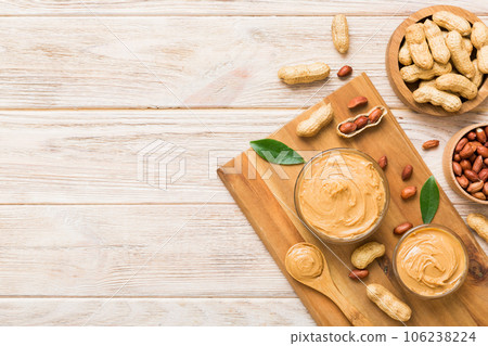Bowl of peanut butter and peanuts on table background. top view with copy space. Creamy peanut pasta in small bowl 106238224