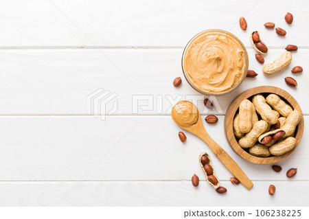 Bowl of peanut butter and peanuts on table background. top view with copy space. Creamy peanut pasta in small bowl Bowl of peanut butter and peanuts on table background. top view with copy space. Creamy peanut pasta in small bowl 106238225
