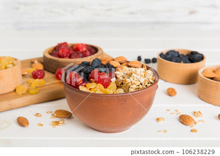 Cooking a wholesome breakfast. Granola with Various dried fruits and nuts in a bowl. The concept of a healthy dessert. Flat lay, top view with copy space 106238229