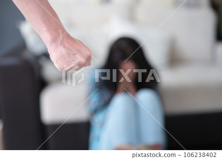 Man stands with fist clenched against background of crying woman Man stands with fist clenched against background of crying woman 106238402
