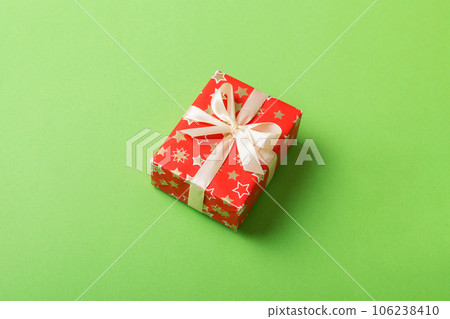 Wrapped christmas or other holiday handmade present in paper with colored ribbon. Present box, decoration of gift on table, top view with copy space 106238410