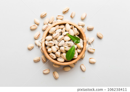 Fresh healthy Pistachios in bowl on colored table background. Top view Healthy eating concept. Super foods Fresh healthy Pistachios in bowl on colored table background. Top view Healthy eating concept. Super foods 106238411
