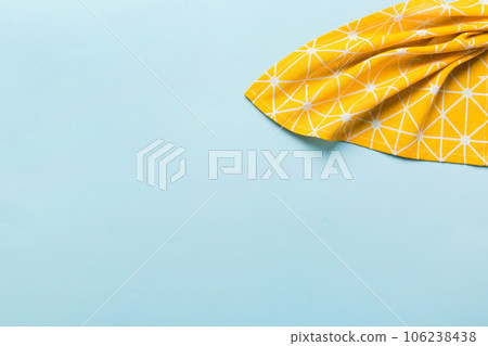 top view with yellow empty kitchen napkin isolated on table background. Folded cloth for mockup with copy space, Flat lay. Minimal style 106238438
