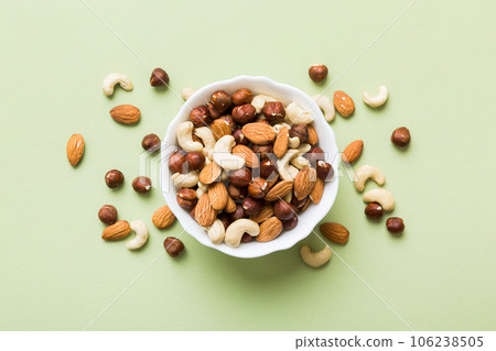 Assortment of nuts in wooden bowl on colored table. Cashew, hazelnuts, walnuts, almonds. Mix of nuts Top view with copy space Assortment of nuts in wooden bowl on colored table. Cashew, hazelnuts, walnuts, almonds. Mix of nuts Top view with copy space 106238505
