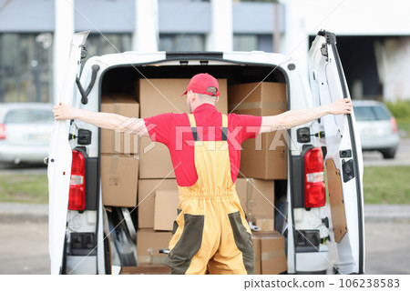 Uniformed male courier opens trunk of minivan filled with cardboard boxes Uniformed male courier opens trunk of minivan filled with cardboard boxes 106238583