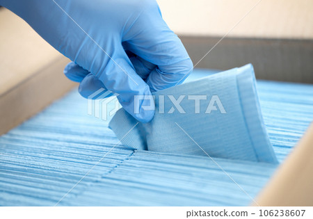 Gloved doctor takes out medical disposable napkins closeup 106238607