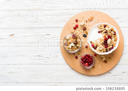 Healthy breakfast food with granola, yogurt, fruits and nuts. Dessert parfait with dried fruits for breakfast 106238895