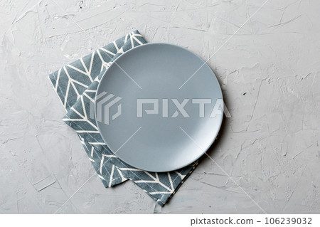 Top view on colored background empty round gray plate on tablecloth for food. Empty dish on napkin with space for your design 106239032