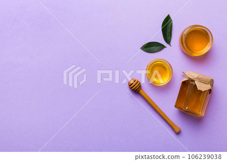 Honey jar with wooden honey dipper on white background top view with copy space. Delicious honey bottle Honey jar with wooden honey dipper on white background top view with copy space. Delicious honey bottle 106239038