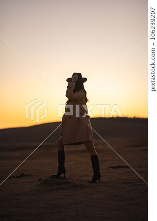 夕陽下，一位穿著風衣的女人在草千里擺姿勢 106239207