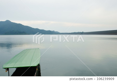 landscape of boat floating  on water reservoir lake with mountain background in sunset  106239909