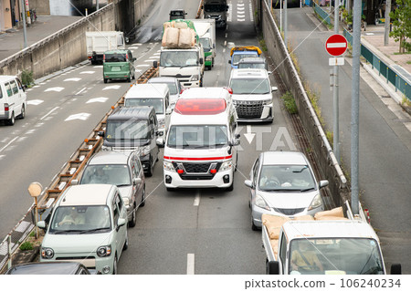 Ambulance driving through a busy road Ambulance driving through a busy road 106240234