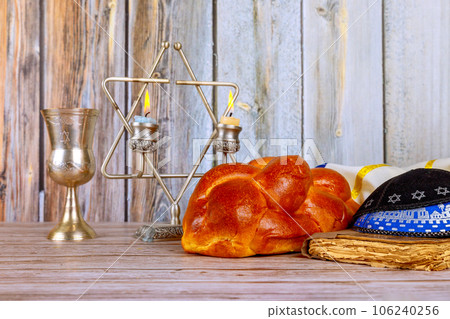 Sabbath Jewish Holiday celebration traditional homemade hallah bread kosher wine and candles on table. 106240256