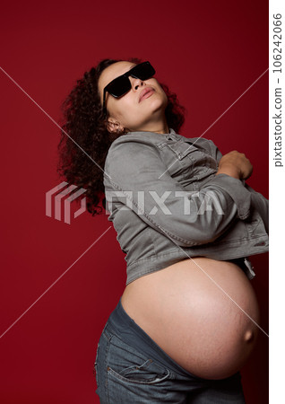 Multi-ethnic pregnant woman isolated over red studio background. Childbearing. Pregnancy. Maternity fashion. Lifestyle 106242066