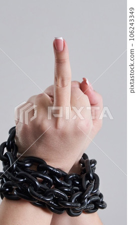 Female chained fist showing a fuck you sign 106243349