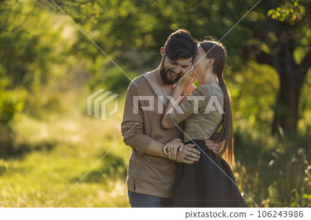 girl says something in the ear of her boyfriend girl says something in the ear of her boyfriend 106243986