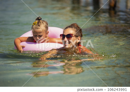 mother and daughter swimming in the sea mother and daughter swimming in the sea 106243991