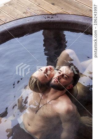 young couple sitting in a tub filled with water young couple sitting in a tub filled with water 106243997