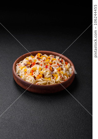 Delicious fresh Asian noodles with pieces of vegetables, meat, with salt, spices and herbs 106244455