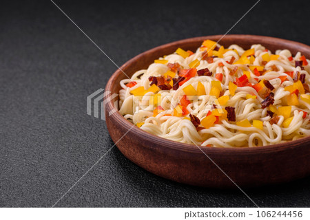Delicious fresh Asian noodles with pieces of vegetables, meat, with salt, spices and herbs Delicious fresh Asian noodles with pieces of vegetables, meat, with salt, spices and herbs 106244456
