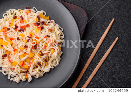 Delicious fresh Asian noodles with pieces of vegetables, meat, with salt, spices and herbs Delicious fresh Asian noodles with pieces of vegetables, meat, with salt, spices and herbs 106244469