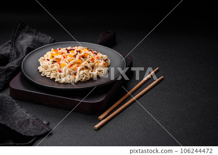 Delicious fresh Asian noodles with pieces of vegetables, meat, with salt, spices and herbs 106244472
