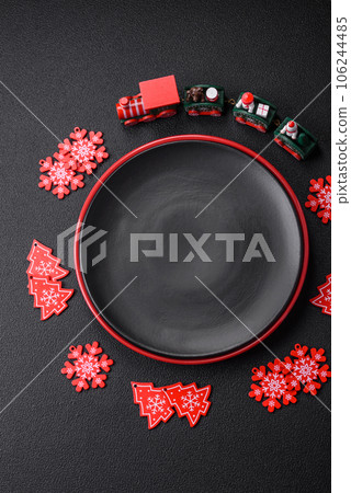 Empty ceramic black plate with christmas decoration elements Empty ceramic black plate with christmas decoration elements 106244485