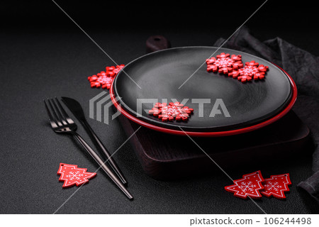 Empty ceramic black plate with christmas decoration elements 106244498