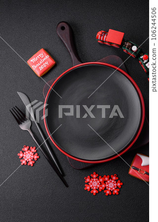 Empty ceramic black plate with christmas decoration elements Empty ceramic black plate with christmas decoration elements 106244506