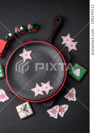 Empty ceramic black plate with christmas decoration elements Empty ceramic black plate with christmas decoration elements 106244512