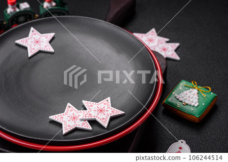 Empty ceramic black plate with christmas decoration elements 106244514