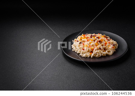 Delicious fresh Asian noodles with pieces of vegetables, meat, with salt, spices and herbs Delicious fresh Asian noodles with pieces of vegetables, meat, with salt, spices and herbs 106244536