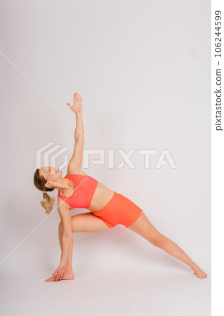 Full length portrait of smiling young woman in sportswear isolated over studio background. 106244599