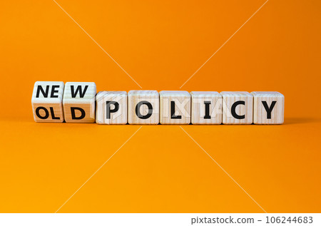 New or old policy symbol. Turned wooden cubes, changed words 'old policy' to 'new policy'. Beautiful orange table, orange background. Business, old or new policy concept. Copy space. 106244683